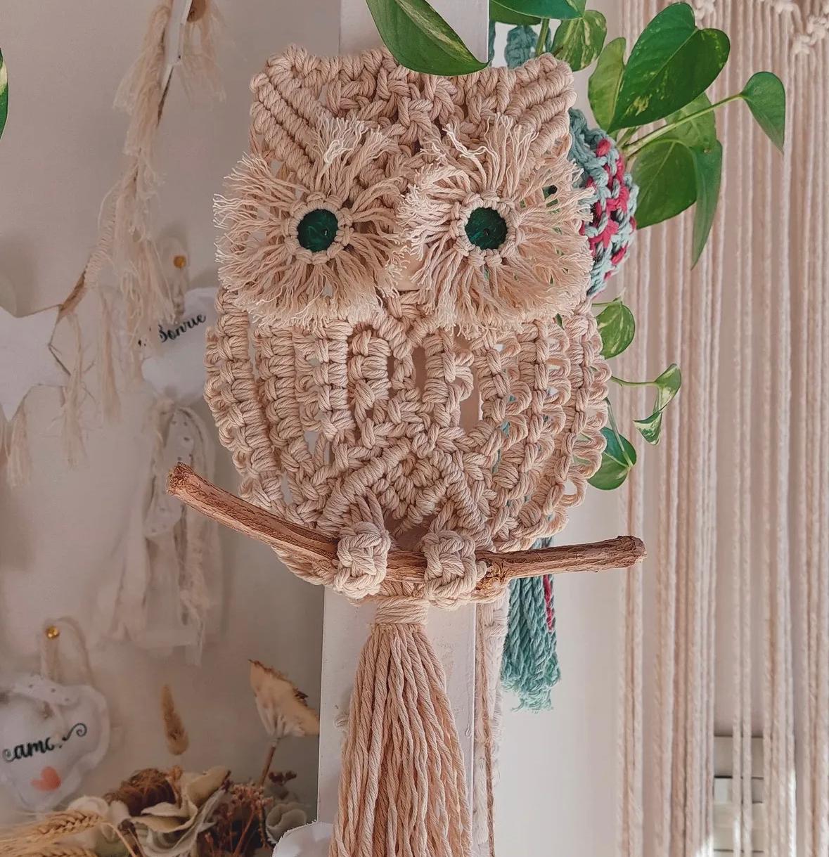 Búho de macramé sobre una rama