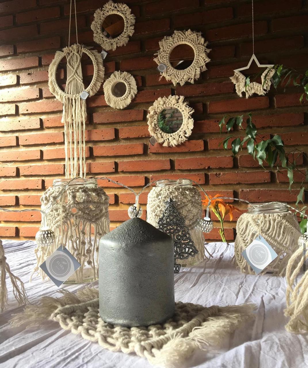 Fanales de macramé con velas y espejos en la pared