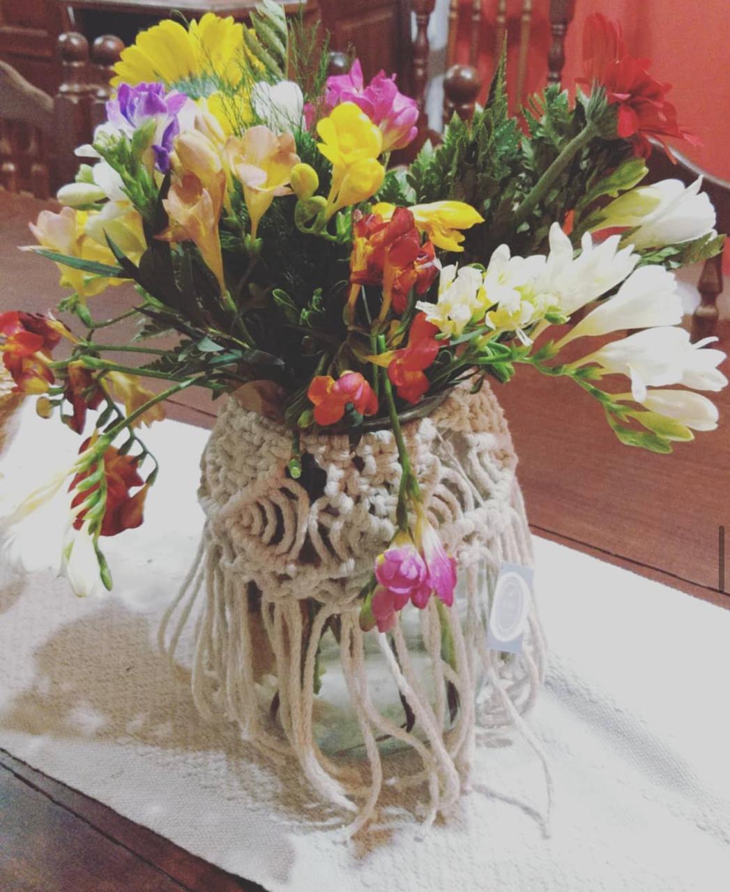 Florero vestido de macramé con flores frescas