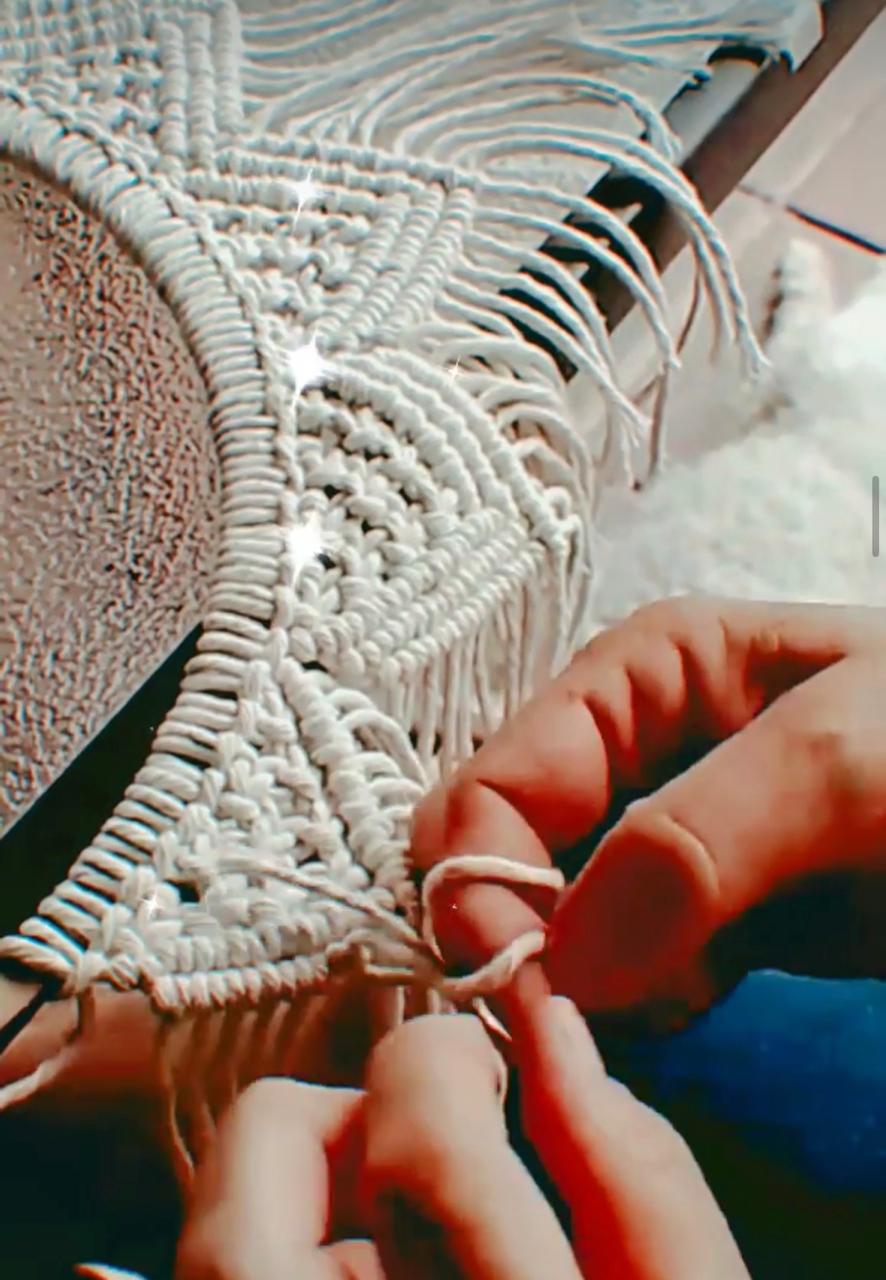 Manos tejiendo un espejo de macramé